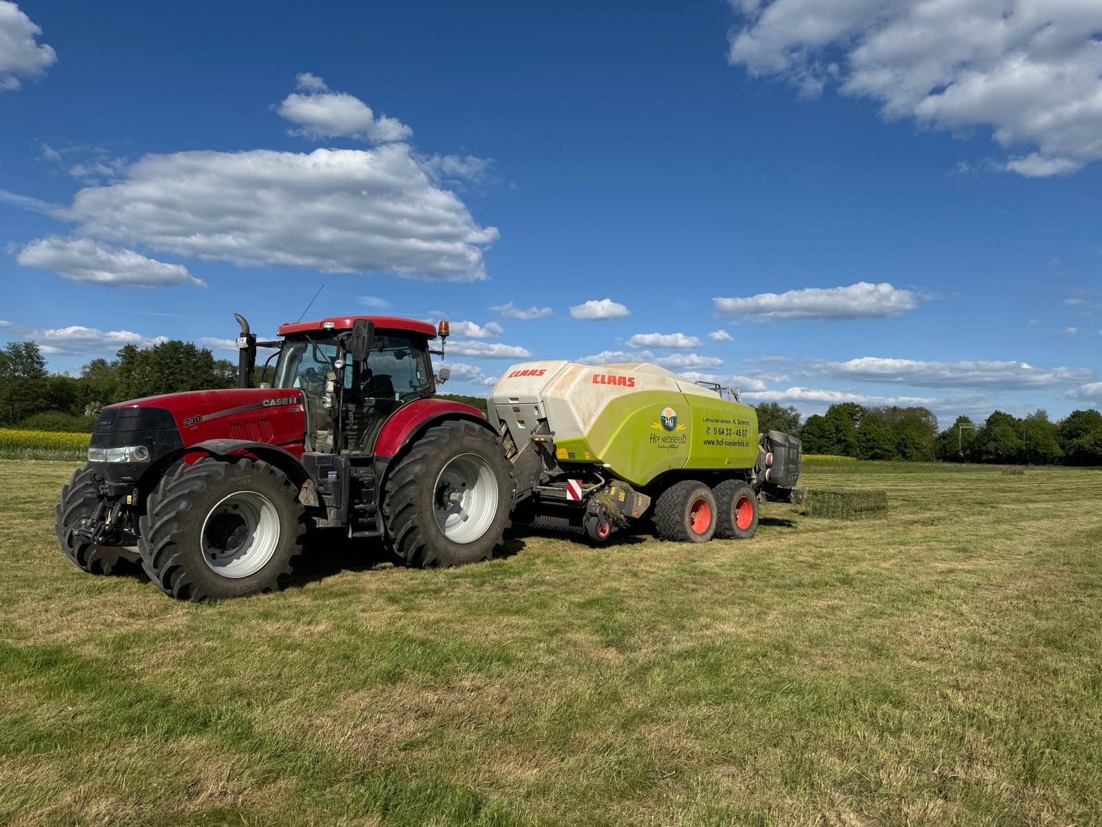 Traktor mit Miststreuer bei der Entsorgung von Gülle auf einem Bauernhof